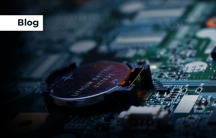 Close-up of a battery on a circuit board, highlighting the details of the battery and surrounding electronic components.